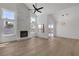 Bright living room featuring a stone fireplace, wood floors, and large windows with views of the lush yard at 1638 Candice St, Las Vegas, NV 89156