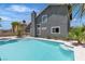 Backyard pool featuring the gray house, blue water, a chimney, palm trees, and stairs at 1638 Candice St, Las Vegas, NV 89156