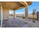This covered back patio offers brick pavers, desert landscaping, and stunning mountain views beyond the black iron fence at 164 Cabo Cruces Dr, Henderson, NV 89011