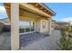 The backyard shows a covered patio, desert landscaping, neutral color stucco, and lovely contrasting trim on the windows at 164 Cabo Cruces Dr, Henderson, NV 89011