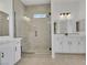 Modern bathroom featuring a tiled shower with a bench, glass enclosure, and double sink vanity with white cabinets at 164 Cabo Cruces Dr, Henderson, NV 89011