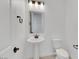Well-lit half bathroom with a pedestal sink, modern fixtures, and a white toilet, offering a clean design at 164 Cabo Cruces Dr, Henderson, NV 89011