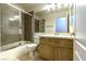 Bathroom featuring a shower and bathtub combo next to a wooden vanity with a sink and toilet at 1721 Mill Canyon Dr, Las Vegas, NV 89128