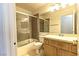 Bathroom featuring a shower and bathtub combo next to a wooden vanity with a sink and toilet at 1721 Mill Canyon Dr, Las Vegas, NV 89128