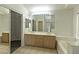 Spacious bathroom with double vanity, large mirror, bathtub, and walk-in closet at 1721 Mill Canyon Dr, Las Vegas, NV 89128