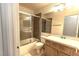 Bathroom featuring a shower and bathtub combo next to a wooden vanity with a sink and toilet at 1721 Mill Canyon Dr, Las Vegas, NV 89128