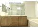 Bathroom with a double sink vanity and a large mirror with plenty of lighting at 1721 Mill Canyon Dr, Las Vegas, NV 89128