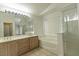 Bright bathroom featuring a double vanity, bathtub, and separate glass-enclosed shower at 1721 Mill Canyon Dr, Las Vegas, NV 89128