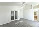 Spacious bedroom featuring plush gray carpet, ceiling fan, and glass paneled double doors at 1721 Mill Canyon Dr, Las Vegas, NV 89128