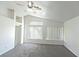 Bright bedroom featuring vaulted ceilings, gray carpet, ceiling fan, and multiple windows with blinds at 1721 Mill Canyon Dr, Las Vegas, NV 89128