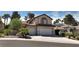 Two-story home featuring lush landscaping, a tiled roof, and two-car garage at 1721 Mill Canyon Dr, Las Vegas, NV 89128