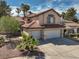 This two-story home boasts a tile roof, desert landscaping, and a spacious two-car garage at 1721 Mill Canyon Dr, Las Vegas, NV 89128