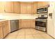 Modern kitchen has light wood cabinets, stainless steel appliances and a tiled floor at 1721 Mill Canyon Dr, Las Vegas, NV 89128