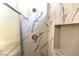 Close-up of shower featuring shower head and shampoo nook with marble tiling at 1721 Mill Canyon Dr, Las Vegas, NV 89128