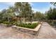 Scenic park with a covered seating area, lush greenery, stone planters, and inviting walking paths at 1976 Galleria Spada St, Henderson, NV 89044