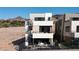 Modern three-story home featuring a rooftop deck with spiral staircase, sleek design, outdoor living spaces, and scenic mountain views at 20 Lakefront Dr, Henderson, NV 89011