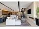 Bright living area featuring modern furnishings, a dining space, sleek fireplace, and staircase with open access to the kitchen at 20 Lakefront Dr, Henderson, NV 89011