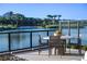 A waterfront patio features a dining table with seating and wrought iron railing overlooking a serene lake and lush landscape at 20 Lakefront Dr, Henderson, NV 89011