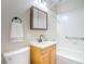 Bright bathroom featuring a white tiled shower/tub, wood vanity, and modern fixtures, creating a clean and functional space at 215 Zinc St, Henderson, NV 89015