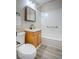 Bright bathroom featuring a white tiled shower/tub, wood vanity, and modern fixtures, creating a clean and functional space at 215 Zinc St, Henderson, NV 89015