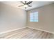 Neutral bedroom with wood-look floors, a ceiling fan, and a bright window at 215 Zinc St, Henderson, NV 89015