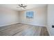Bright bedroom features neutral walls, wood-look floors, a ceiling fan, and a window providing natural light at 215 Zinc St, Henderson, NV 89015