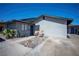 Exterior view showcases a gray low-rise apartment with a gravel yard and two wooden chairs at 215 Zinc St, Henderson, NV 89015