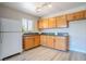 Eat-in kitchen with wood cabinets, black counters, stainless sink and light wood-look floors at 215 Zinc St, Henderson, NV 89015
