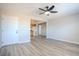 Open living room features wood-look floors, ceiling fan and an entry door leading to the kitchen at 215 Zinc St, Henderson, NV 89015