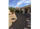 A gravel-covered backyard that has a covered patio and is surrounded by mature vegetation at 2175 Clearwater Lake Dr, Henderson, NV 89044