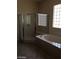 Bright bathroom featuring a separate glass shower, tub, and patterned window at 2175 Clearwater Lake Dr, Henderson, NV 89044