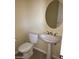 Stylish powder room featuring modern fixtures, pedestal sink and an oval mirror at 2175 Clearwater Lake Dr, Henderson, NV 89044