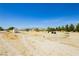 Expansive desert landscape with a car and various structures, set against a clear sky at 2251 Bridger St, Pahrump, NV 89048