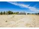 Desert landscape with a home featuring solar panels and a backdrop of clear blue skies at 2251 Bridger St, Pahrump, NV 89048