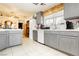 Well-lit kitchen featuring gray cabinets, tile countertops, and a view into the dining area at 2251 Bridger St, Pahrump, NV 89048