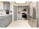 Contemporary kitchen featuring stainless steel appliances, gray cabinets, and tile backsplash at 2251 Bridger St, Pahrump, NV 89048