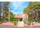 View of the clubhouse entrance with landscaped grounds, mature trees, and American flag at 2851 S Valley View Blvd # 1071, Las Vegas, NV 89102