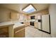 Bright kitchen featuring wood cabinets, tile floors, and modern appliances under a skylight at 2851 S Valley View Blvd # 1199, Las Vegas, NV 89102