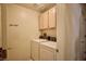 Laundry room with white washer and dryer, upper cabinets, and neutral walls at 2851 S Valley View Blvd # 1199, Las Vegas, NV 89102