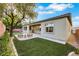 Spacious backyard featuring synthetic grass, exterior patio, and desert landscaping at 2921 Guillemot Ave, North Las Vegas, NV 89084