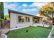 Spacious backyard featuring a putting green, desert landscaping, and a covered patio at 2921 Guillemot Ave, North Las Vegas, NV 89084