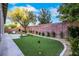 Low-maintenance backyard with artificial turf, desert landscaping, putting green and a brick wall at 2921 Guillemot Ave, North Las Vegas, NV 89084