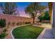 Beautiful backyard featuring artificial turf, desert landscaping, and a brick privacy wall at 2921 Guillemot Ave, North Las Vegas, NV 89084
