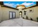 Exterior courtyard featuring an arched entryway, double doors, and manicured landscaping at 2921 Guillemot Ave, North Las Vegas, NV 89084