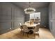 Dining room with designer lighting, gray accent wall, wood table with seating, and wood floors at 2921 Guillemot Ave, North Las Vegas, NV 89084