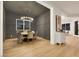 Dining room with designer lighting, gray accent wall, wood table with seating, and wood floors at 2921 Guillemot Ave, North Las Vegas, NV 89084