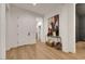 Inviting foyer with light wood floors, white walls, console table, and entry door at 2921 Guillemot Ave, North Las Vegas, NV 89084