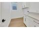 Well-lit laundry room featuring ample storage cabinets and modern light fixtures at 2921 Guillemot Ave, North Las Vegas, NV 89084