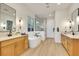 Spacious bathroom with dual vanities, a modern soaking tub, and a glass-enclosed shower at 2921 Guillemot Ave, North Las Vegas, NV 89084