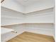 A walk-in closet with wood shelving and ample storage space with wood-look floors at 2921 Guillemot Ave, North Las Vegas, NV 89084